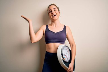 Spor kıyafetleri giyen genç, sarışın, spor giysili, çok mutlu ve heyecanlı, kazanan yüz ifadesi zaferi büyük bir gülümsemeyle kutluyor ve ellerini kaldırıyor.