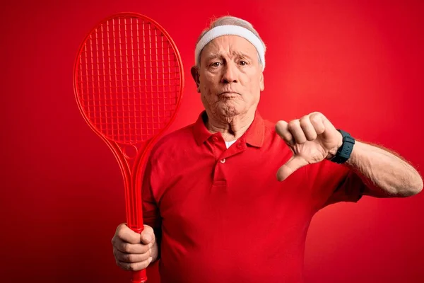 Hombre Tenista Senior Pelo Gris Sosteniendo Raqueta Sobre Fondo Rojo —  Fotos de Stock