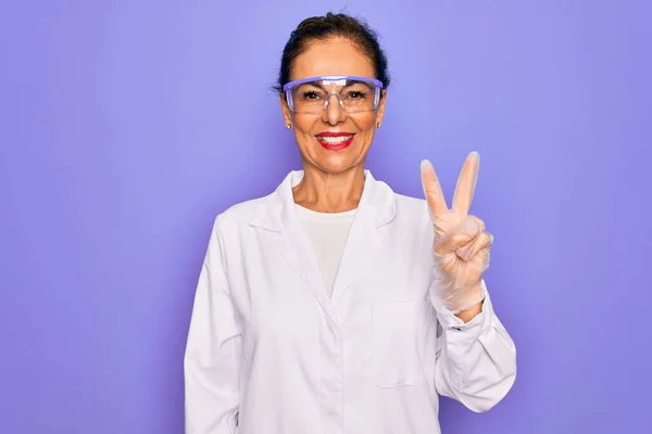 Middelbare Leeftijd Senior Wetenschapper Vrouw Dragen Jas Laboratoriumbril Paarse Achtergrond — Stockfoto