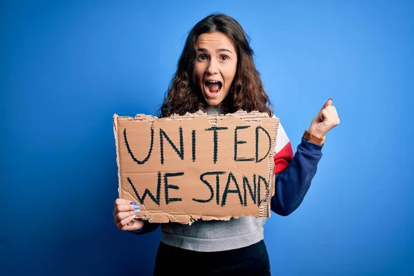 青い背景の上に統一されたスタンドメッセージを持つ美しい活動家の女性は誇りを叫び 勝利と成功を祝う非常に興奮し 応援感情 — ストック写真