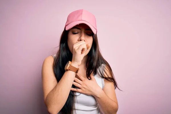 年轻的黑发女子头戴休闲运动帽 背景粉色 感觉不舒服 咳嗽是感冒或支气管炎的症状 保健概念 — 图库照片