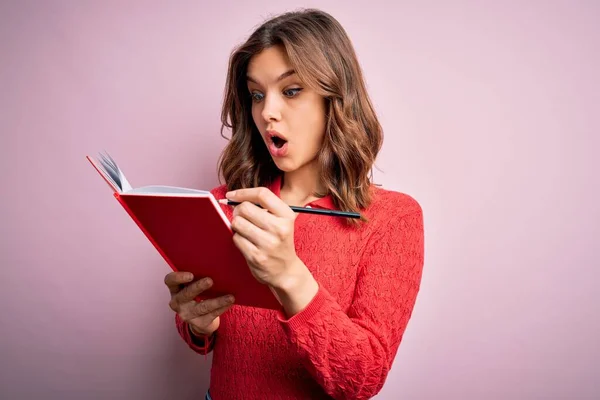 Junge Blonde Studentin Liest Ein Buch Über Rosa Isolierten Hintergrund — Stockfoto