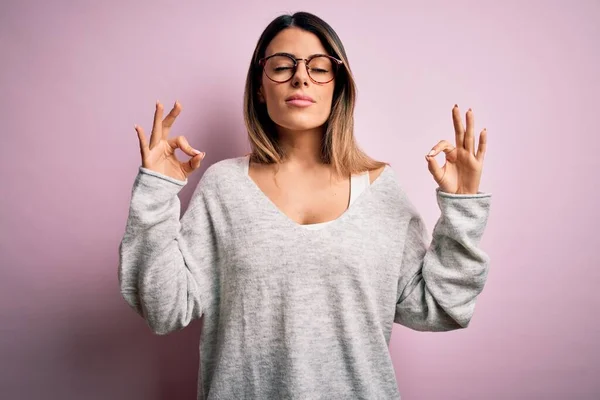 Młoda Piękna Brunetka Ubrana Luźny Sweter Okulary Różowym Tle Relaksuje — Zdjęcie stockowe