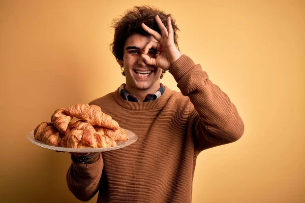 Mladý Pohledný Muž Držící Talíř Croissanty Stojící Nad Izolovaným Žlutým — Stock fotografie