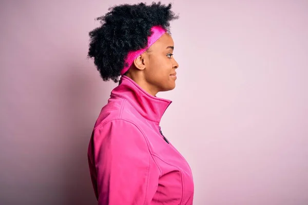 年轻美丽的非洲裔美国女运动员 身穿粉色运动服 面带微笑 自然地放松姿态 — 图库照片