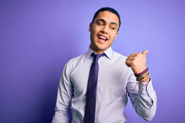 年轻的巴西商人 戴着雅致的领带 站在孤立的紫色背景上 面带微笑 面带微笑 手指头指向旁边 — 图库照片