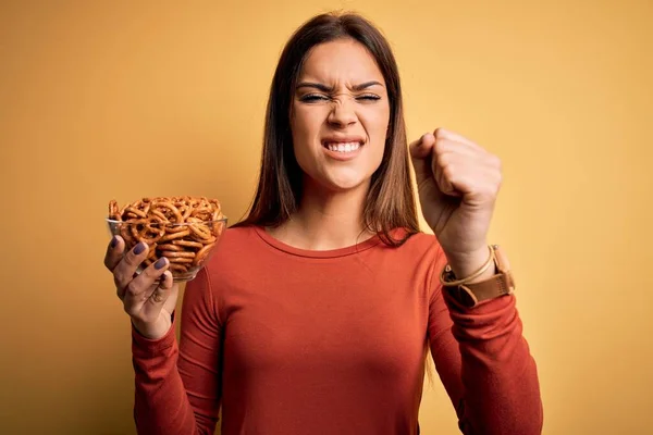 Young Beautiful Brunette Woman Holding Bowl Germany Baked Pretzels Annoyed — Stock Photo, Image