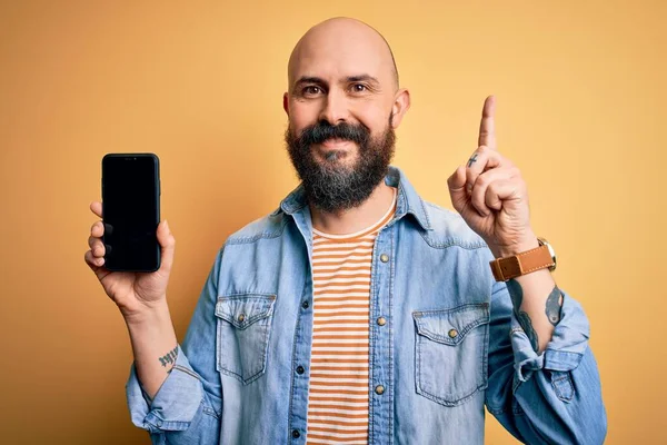 Sakallı Yakışıklı Kel Adam Elinde Akıllı Telefon Sarı Arka Planda — Stok fotoğraf