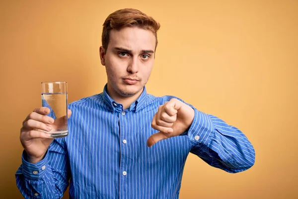 Ung Stilig Rödhårig Man Dricker Glas Vatten Över Isolerad Gul — Stockfoto