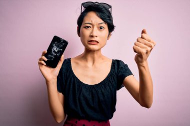 Genç, güzel Çinli bir kadın elinde kırık bir akıllı telefon tutarken ekranda gıcırdayan, sinirli ve sinirli bir şekilde bağırıyor. Öfkeyle bağırıyor.