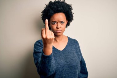 Young beautiful African American afro woman with curly hair wearing casual sweater Showing middle finger, impolite and rude fuck off expression