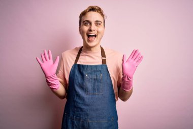 Önlük ve eldivenlerle ev işi yapan yakışıklı kızıl saçlı temizlikçi çılgın ve başarıyı kutlarken kolları açık, gözleri açık heyecanlı bir şekilde haykırıyor. Kazanan konsept