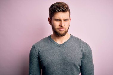 Sakallı, mavi gözlü, sıradan bir süveter giyen, kuşkucu ve gergin, sorunlarından dolayı surat asan yakışıklı sarışın genç bir adam. Negatif kişi.