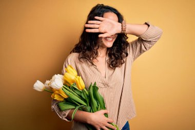 Sarı lale buketi tutan kıvırcık saçlı, genç, romantik bir kadın gülümseyen, güler yüzlü, elleri havada dikizcilik oynayan. Şaşırdım ve çıktım.