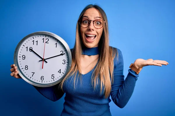 Young Blonde Woman Blue Eyes Holding Big Minute Clock Isolated — Stock Photo, Image