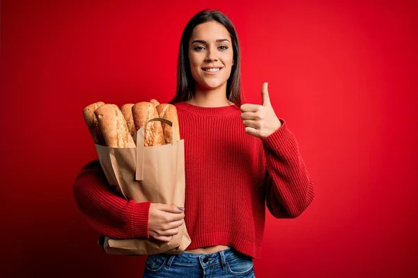 Νεαρή Όμορφη Μελαχρινή Γυναίκα Κρατώντας Χάρτινη Τσάντα Ψωμί Πάνω Από — Φωτογραφία Αρχείου