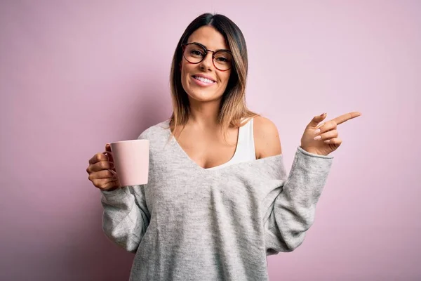 Νεαρή Όμορφη Μελαχρινή Γυναίκα Φορώντας Γυαλιά Πίνοντας Ροζ Κούπα Καφέ — Φωτογραφία Αρχείου