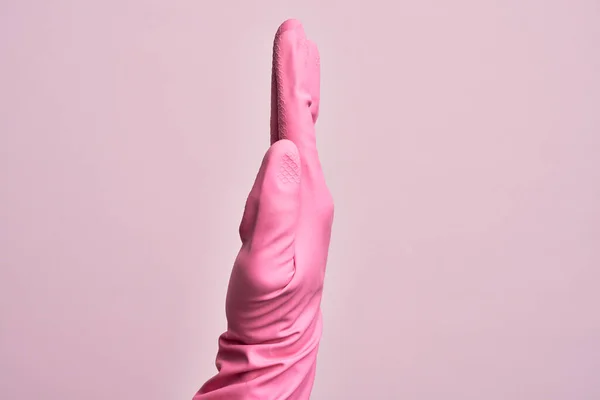 一只带着清洁手套的高加索年轻人的手 在孤立的粉色背景上显示伸出的手的侧面 推动并做停止动作 — 图库照片