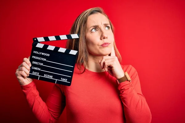 Giovane Bella Bionda Applauso Donna Tenendo Clapboard Sfondo Rosso Isolato — Foto Stock