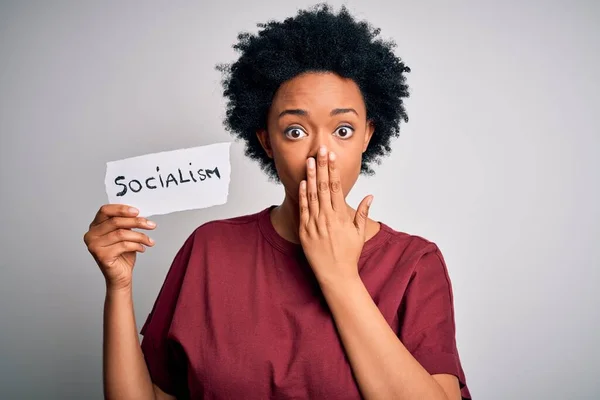 Young African American afro politician woman with curly hair socialist party member cover mouth with hand shocked with shame for mistake, expression of fear, scared in silence, secret concept