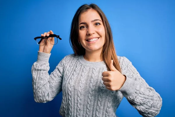 Mulher Loira Jovem Segurando Óculos Óculos Ópticos Sobre Fundo Isolado — Fotografia de Stock