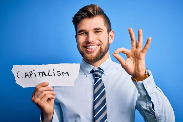 Young Blond Businessman Beard Blue Eyes Holding Paper Capitalism Message — Stock Photo, Image