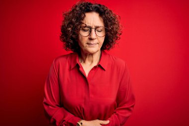 Orta yaşlı, kıvırcık saçlı, rahat gömlekli, kırmızı arka planda gözlüklü, hazımsızlık çeken, ağrılı bir hastalığı olan güzel bir kadın. Ache kavramı.