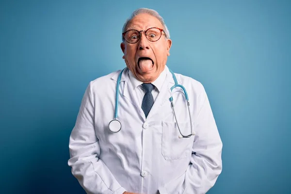 Starszy Siwowłosy Lekarz Noszący Stetoskop Płaszcz Medyczny Niebieskim Tle Wystający — Zdjęcie stockowe