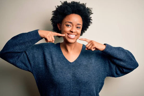 若い美しいアフリカ系アメリカ人のアフロの女性は 明るい表情と指の歯と口を指して笑顔カジュアルなセーターを着て巻き毛 歯科衛生の概念 — ストック写真