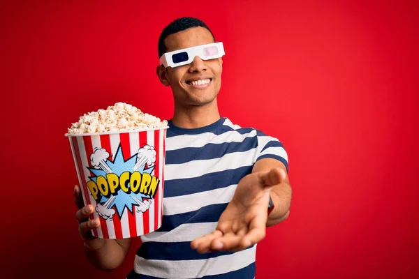 年轻英俊的非洲裔美国人 拿着3D眼镜看电影 吃着爆米花 开心地微笑着 伸出援助和接纳的手 — 图库照片