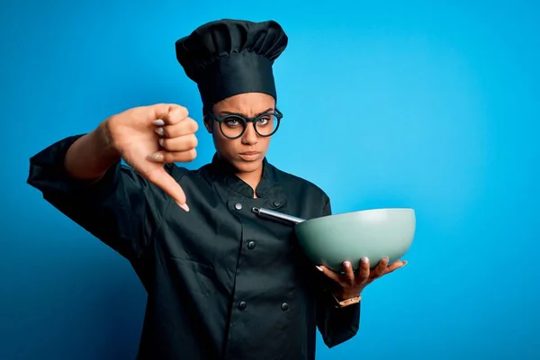 年轻的非洲女厨师身穿炊具制服 头戴礼帽 满脸怒容 不喜欢戴大拇指的负面标志 被拒绝的观念 — 图库照片