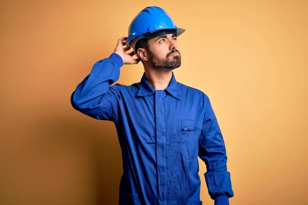 Mechaniker Mit Bart Blauer Uniform Und Schutzhelm Vor Gelbem Hintergrund — Stockfoto