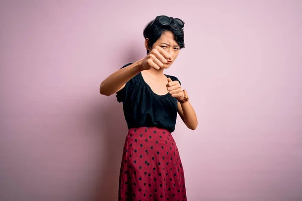 年轻美丽的亚洲女孩穿着休闲装 站在孤立的粉色背景之上 拳打脚踢 咄咄逼人和愤怒的攻击 威胁和暴力 — 图库照片