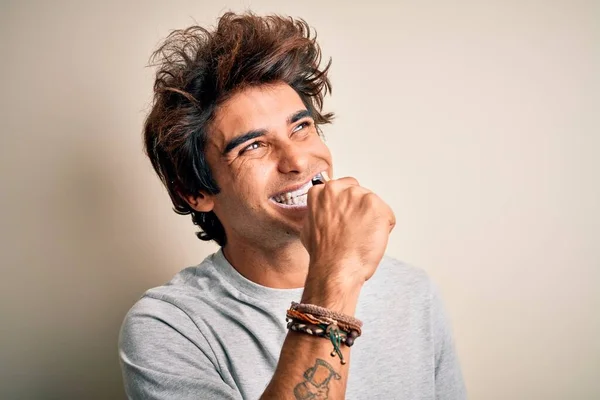 幸せな笑顔の若いハンサムな男 白い背景の上に歯ブラシを使用して顔に笑顔で立ちます — ストック写真