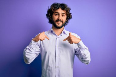 Mor arka plan üzerinde duran sakallı, genç ve yakışıklı bir iş adamı yüzünde bir gülümsemeyle gururlu ve mutlu bir şekilde kendini gösteriyor..