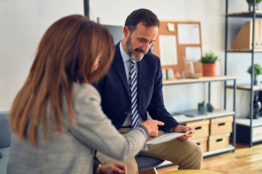 Mutlu ve kendinden emin gülümseyen iki orta yaşlı iş adamı. Ofiste evrakları tutarken gülümseme ile birlikte çalışmak.