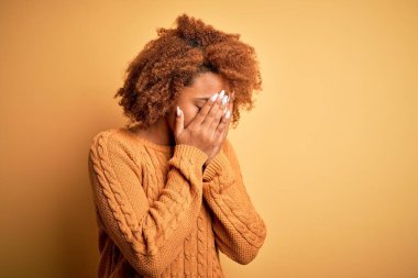 Kıvırcık saçlı, sıradan bir kazak giyen, suratını ellerle kapatıp ağlayan güzel Afro-Amerikan bir kadın. Depresyon kavramı.