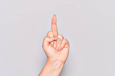Hand of caucasian young woman showing provocative and rude gesture doing fuck you symbol with middle finger