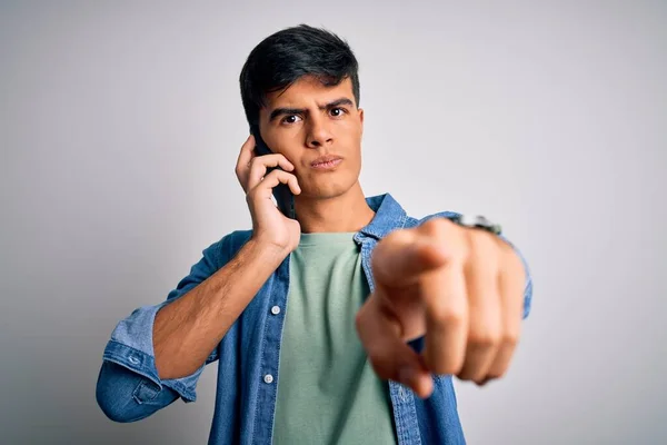 Jovem Homem Bonito Conversando Smartphone Sobre Fundo Branco Apontando Com — Fotografia de Stock