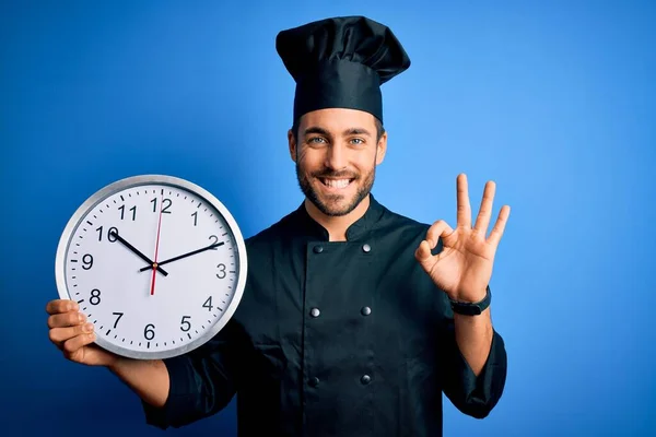 Joven Hombre Guapo Cocina Con Barba Llevando Uniforme Sosteniendo Reloj —  Fotos de Stock