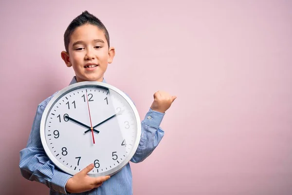 Маленький Мальчик Держит Большие Минутные Часы Изолированном Розовом Фоне Указывая — стоковое фото