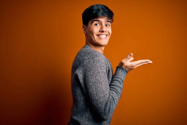 Pemuda Tampan Mengenakan Sweater Kasual Berdiri Atas Latar Belakang Oranye — Stok Foto