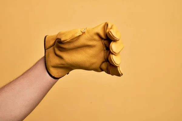 Mão Homem Jovem Caucasiano Com Luva Jardineiro Sobre Fundo Amarelo — Fotografia de Stock