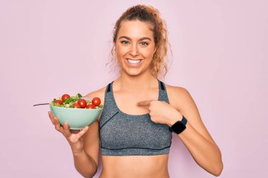 Genç, güzel, sarışın, mavi gözlü, sağlıklı salatalı, süpriz yüzlü, kendini gösteren mavi gözlü bir kadın.