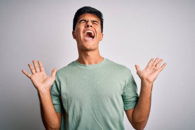 İzole edilmiş beyaz arka plan üzerinde dikilmiş kollarını kaldırmış, gözlerini kapatmış heyecanlı çığlıklar atarak başarıyı kutlayan genç ve yakışıklı bir adam. Kazanan konsept