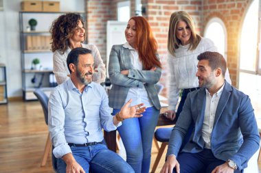 Group of business workers smiling happy and confident. Speaking relaxed together with smile on face at the office
