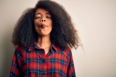 Güzel, Afro-Amerikalı bir kadın izole edilmiş arka planda günlük gömlekler giyiyor. Dudaklarıyla balık suratı yapıyor, çılgınca ve komik bir jest yapıyor. Komik ifade.