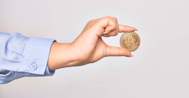 Beyaz arka planda altın Bitcoin parası taşıyan Kafkas genç bir kadın.