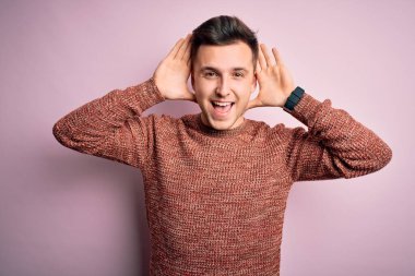 Pembe izole edilmiş arka plan üzerine sıradan bir kazak giyen yakışıklı beyaz bir adam gülümseyen, güler yüzlü, elleri havada dikizleme oyunu oynayan. Şaşırdım ve çıktım.