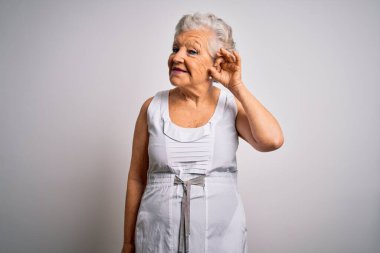 Son sınıf güzeli, gri saçlı, beyaz arka planda rahat bir yaz elbisesi giyen, el pençe divan durup dedikoduları dinleyen bir kadın. Sağırlık kavramı.